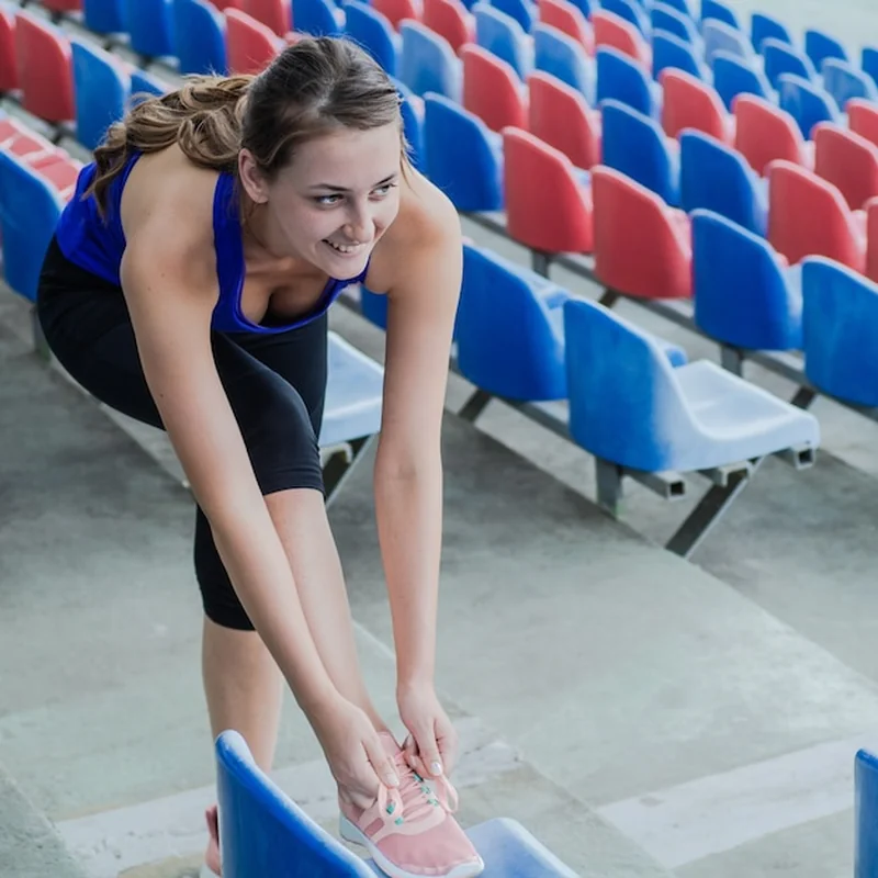 Kobieta w odzieży sportowej wykonuje ćwiczenia fitness jogi na ulicy