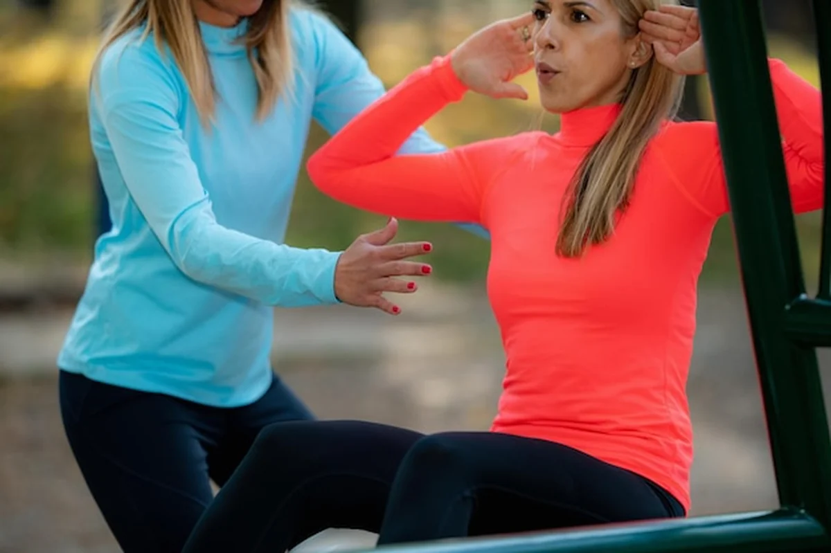Kobieta ćwicząca z trenerem na siłowni na świeżym powietrzu jesienią