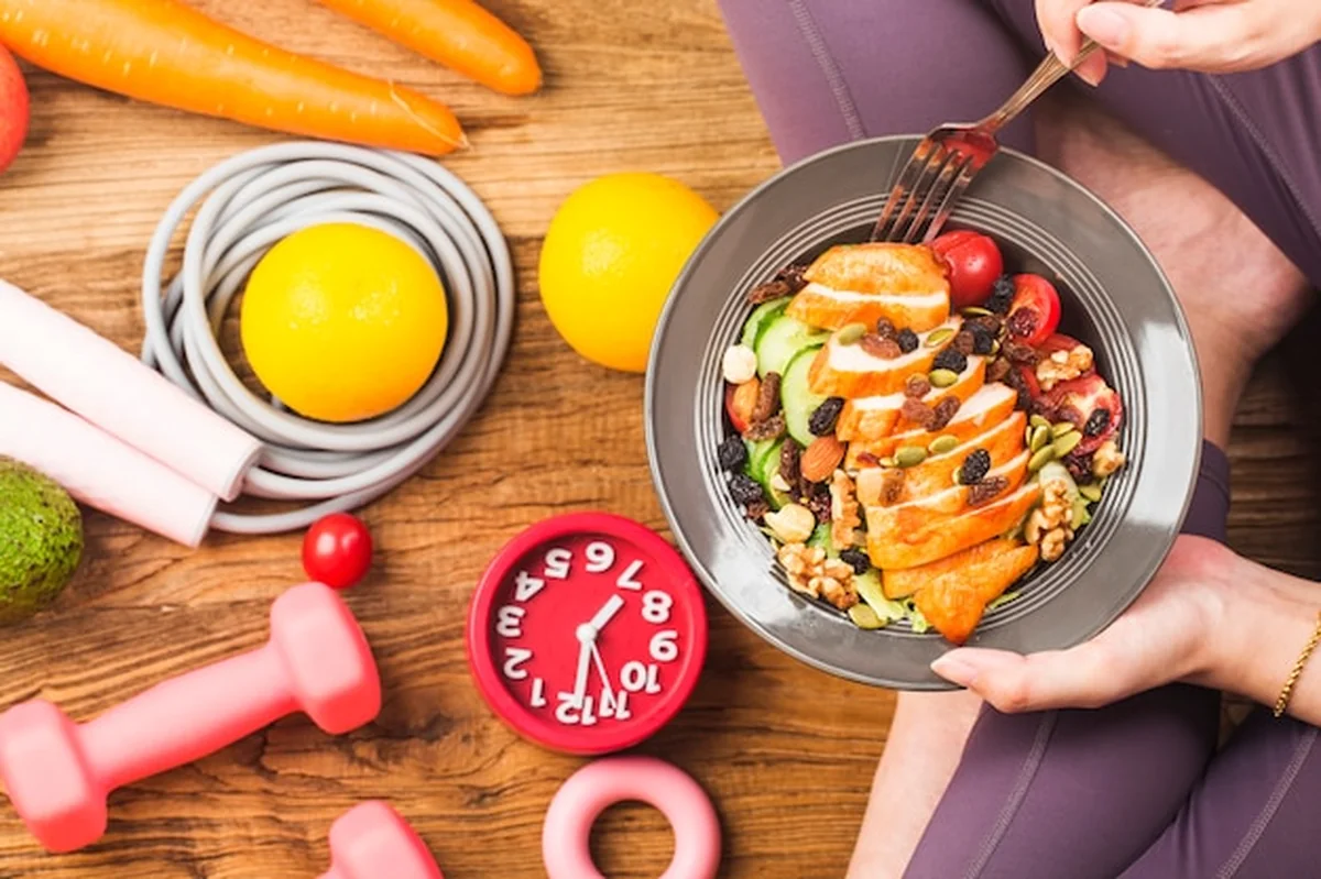 Kobieta w sporcie trzymająca naczynie ze świeżą sałatką