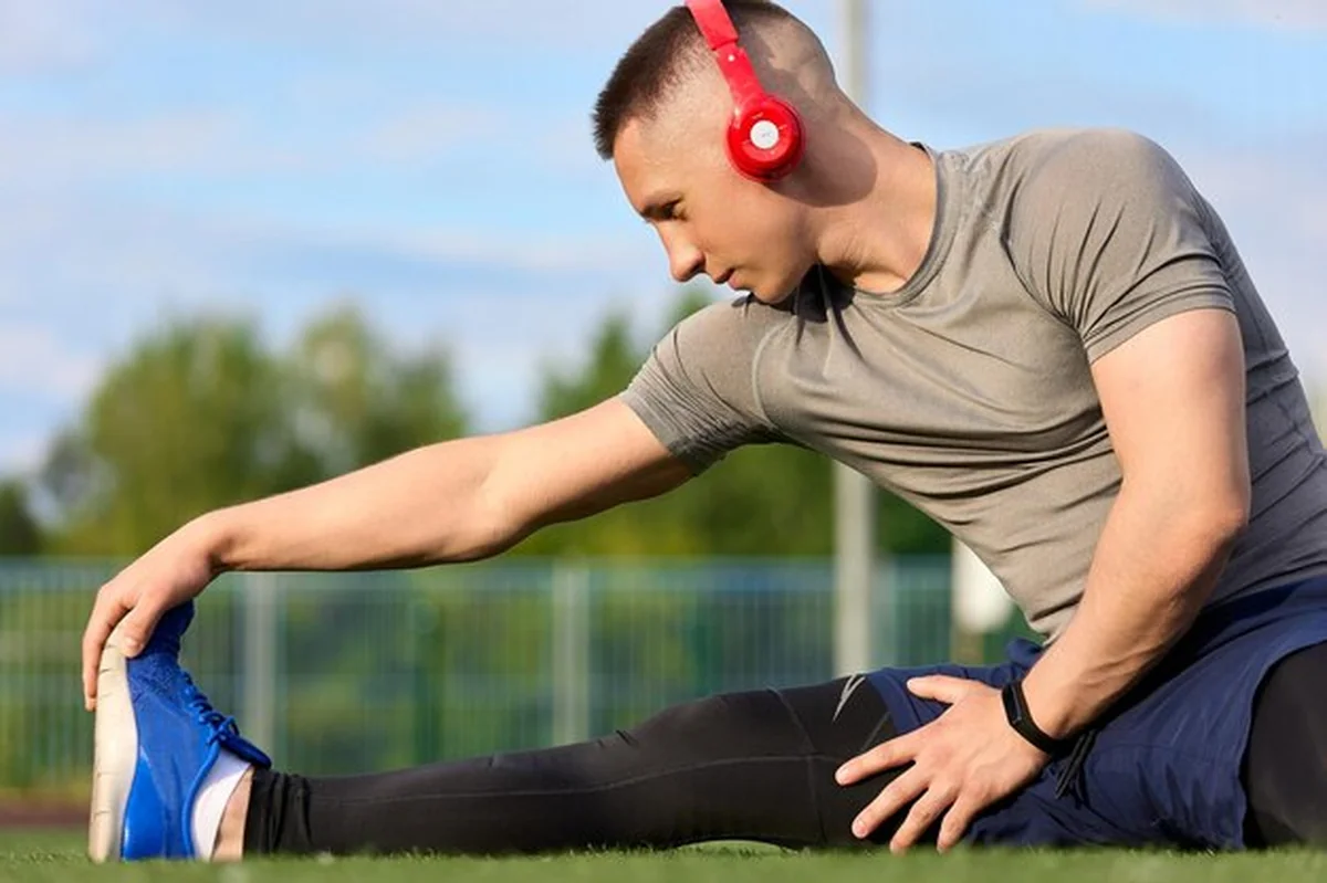 Biegacz gniotący nogi przed treningiem