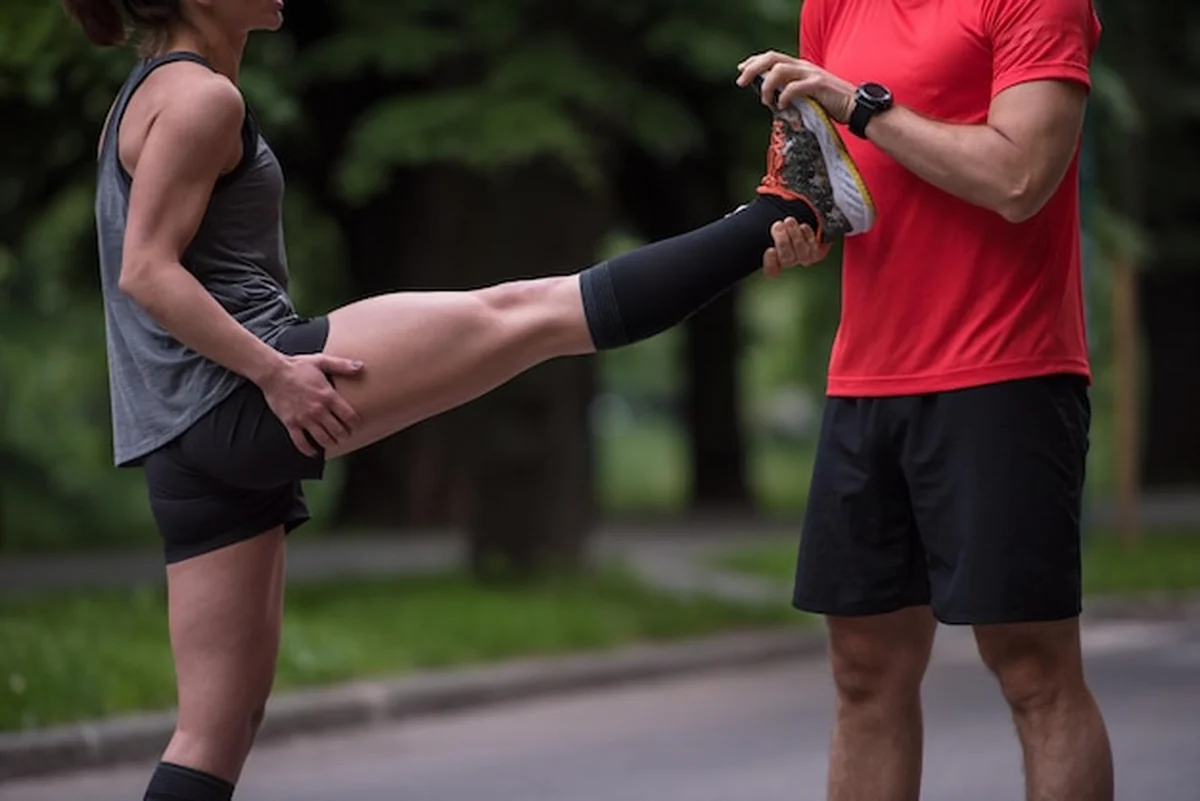 Zdrowa drużyna biegaczy rozgrzewająca się w miejskim parku przed treningiem porannym