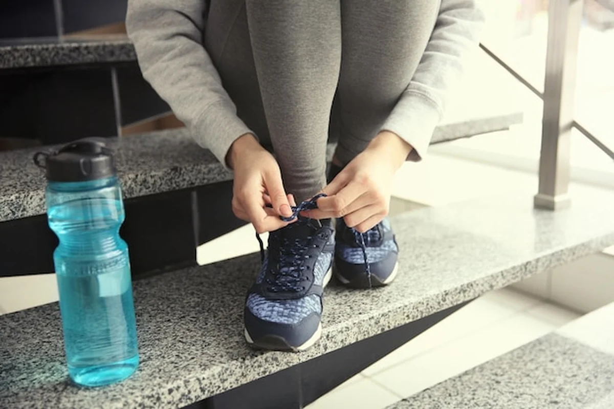 Kobieta wiąże buty do biegania